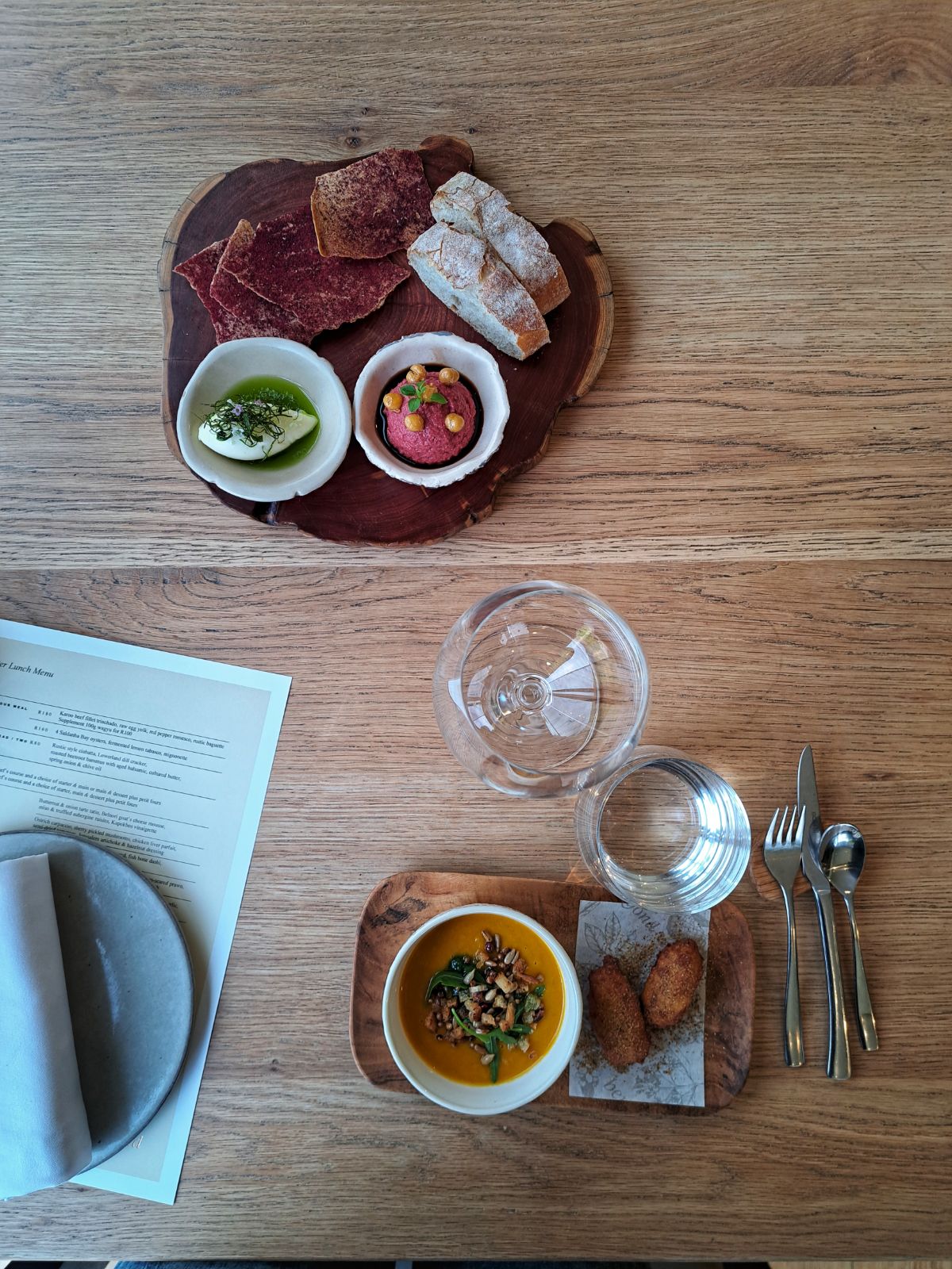 Sortiment von Vorspeisen, Speisekarte und Weinglas in einem Restaurant in Kapstadts Weinregion