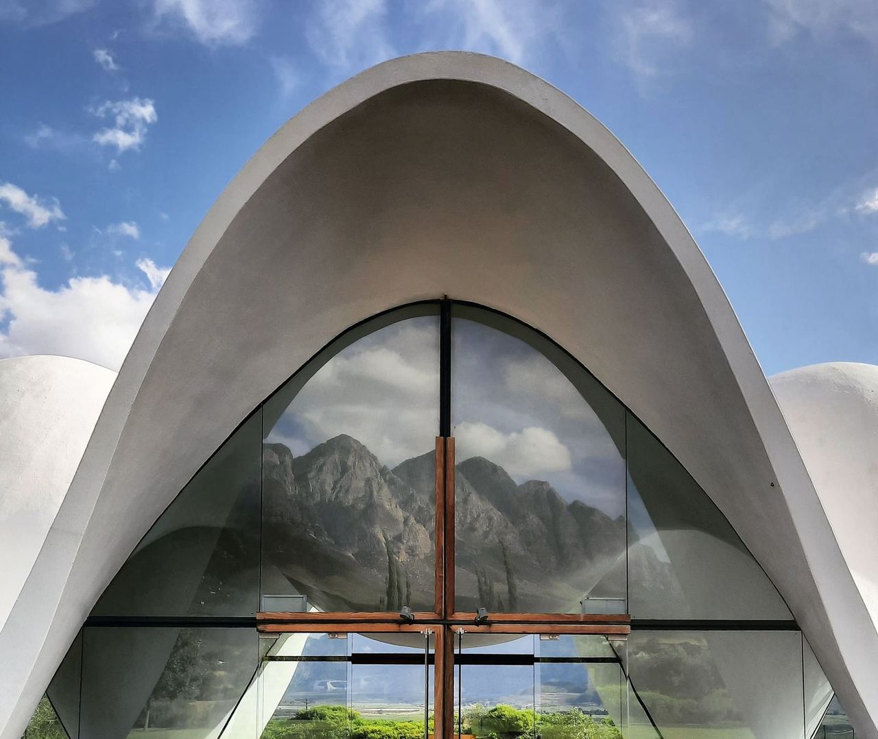 Spiegelbild des Waaihoek-Gebirgszugs in den Fenstern der Hochzeitskapelle, Bosjes Weingut, Breede River Valley, Südafrika
