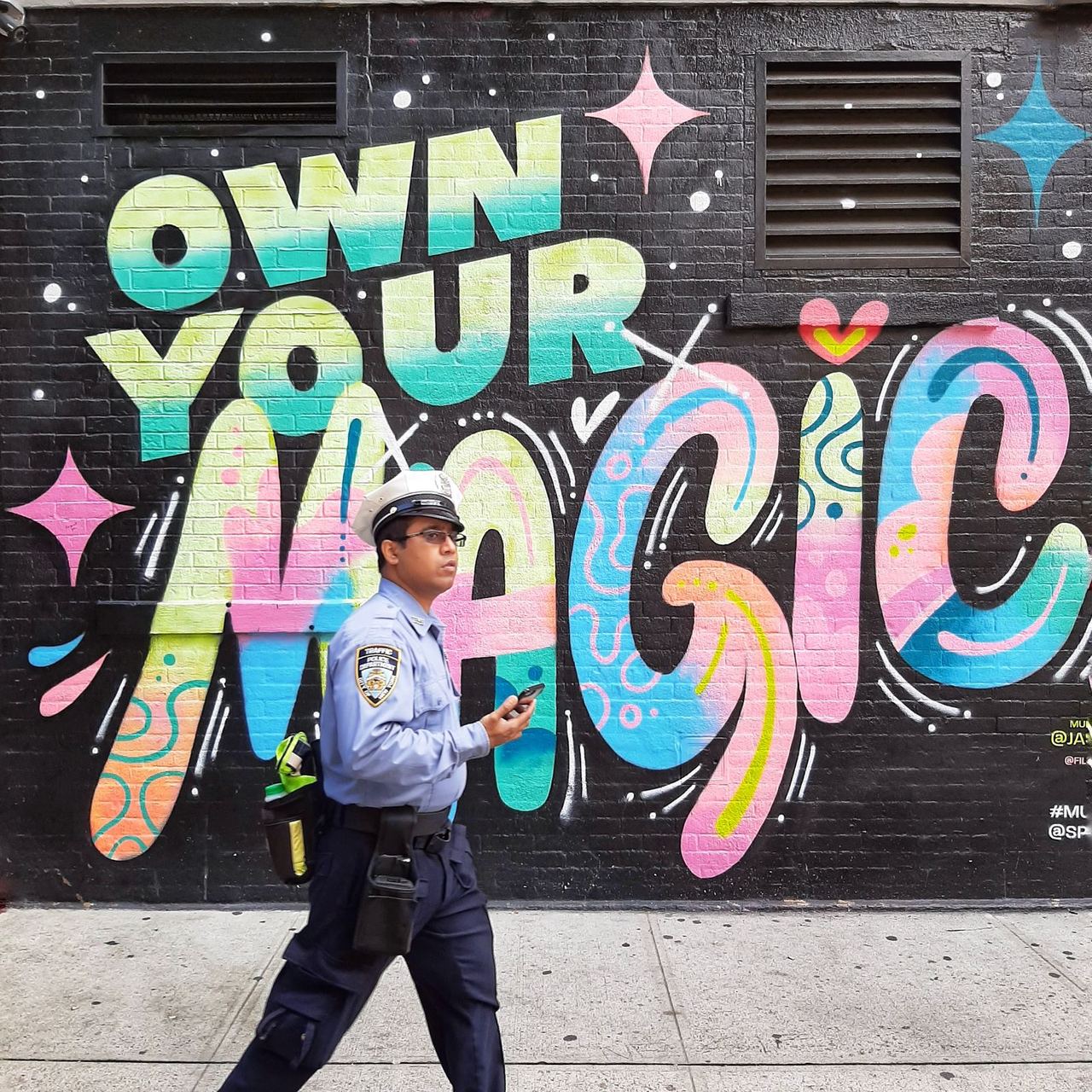 Amerikanischer Polizist in Uniform vor einem Graffiti in New York City