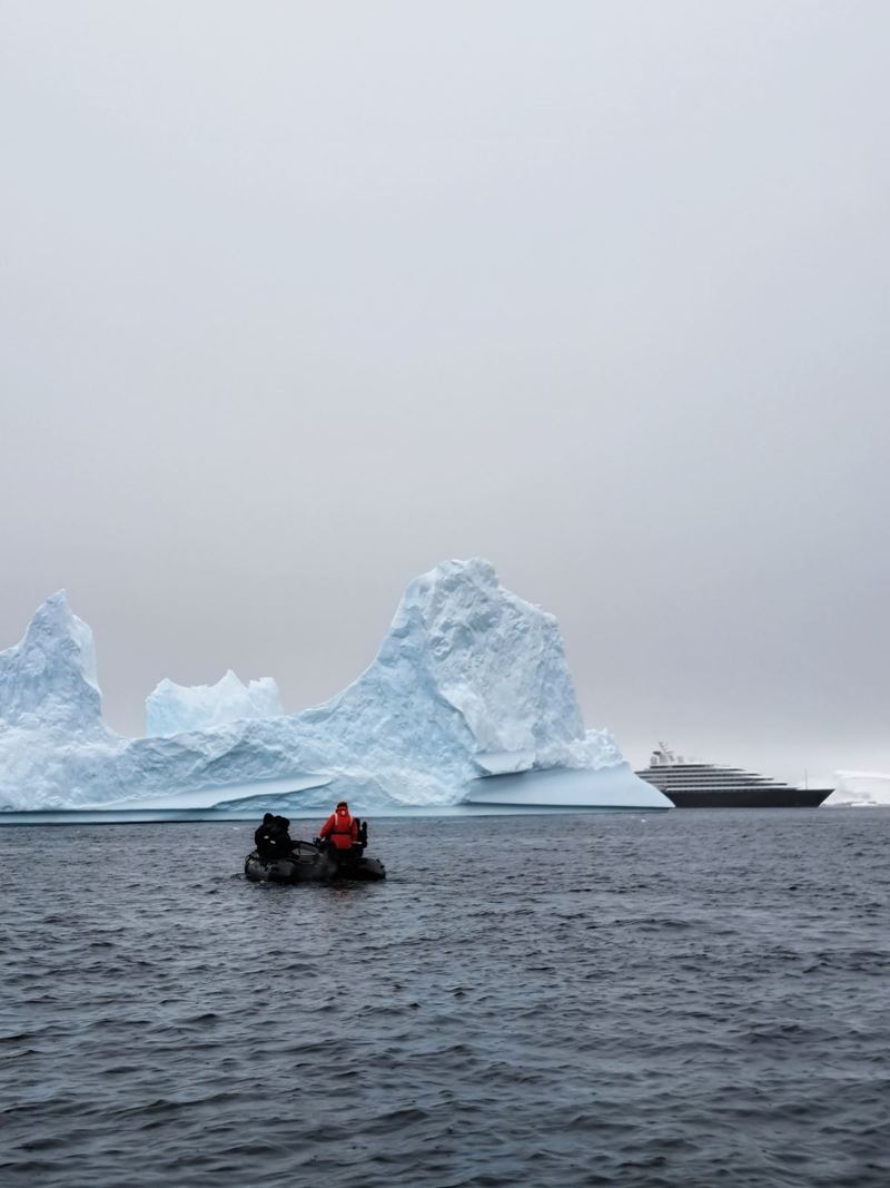 Luxus-Kreuzfahrtschiff Scenic Eclipse und motorgesteuertes Schlauchboot in der Nähe eines Eisbergs in der Antarktis